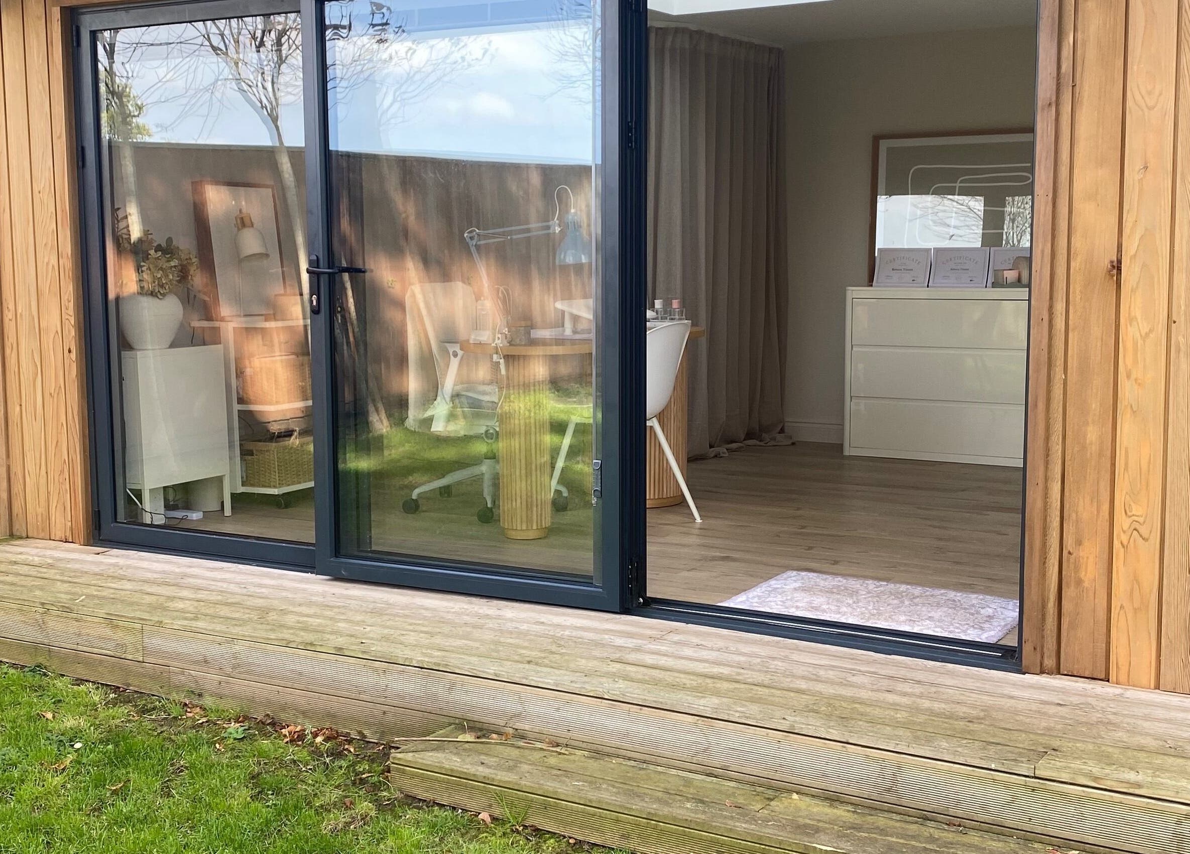Beautiful garden view of Bloom & Noble Nails studio in Swindon, England, GB through glass doors.