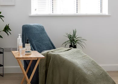 Cozy therapy room at Stephanie Moore Reflexology in Derby, England, GB with armchair and plants.