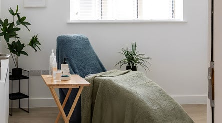 Cozy therapy room at Stephanie Moore Reflexology in Derby, England, GB with armchair and plants.