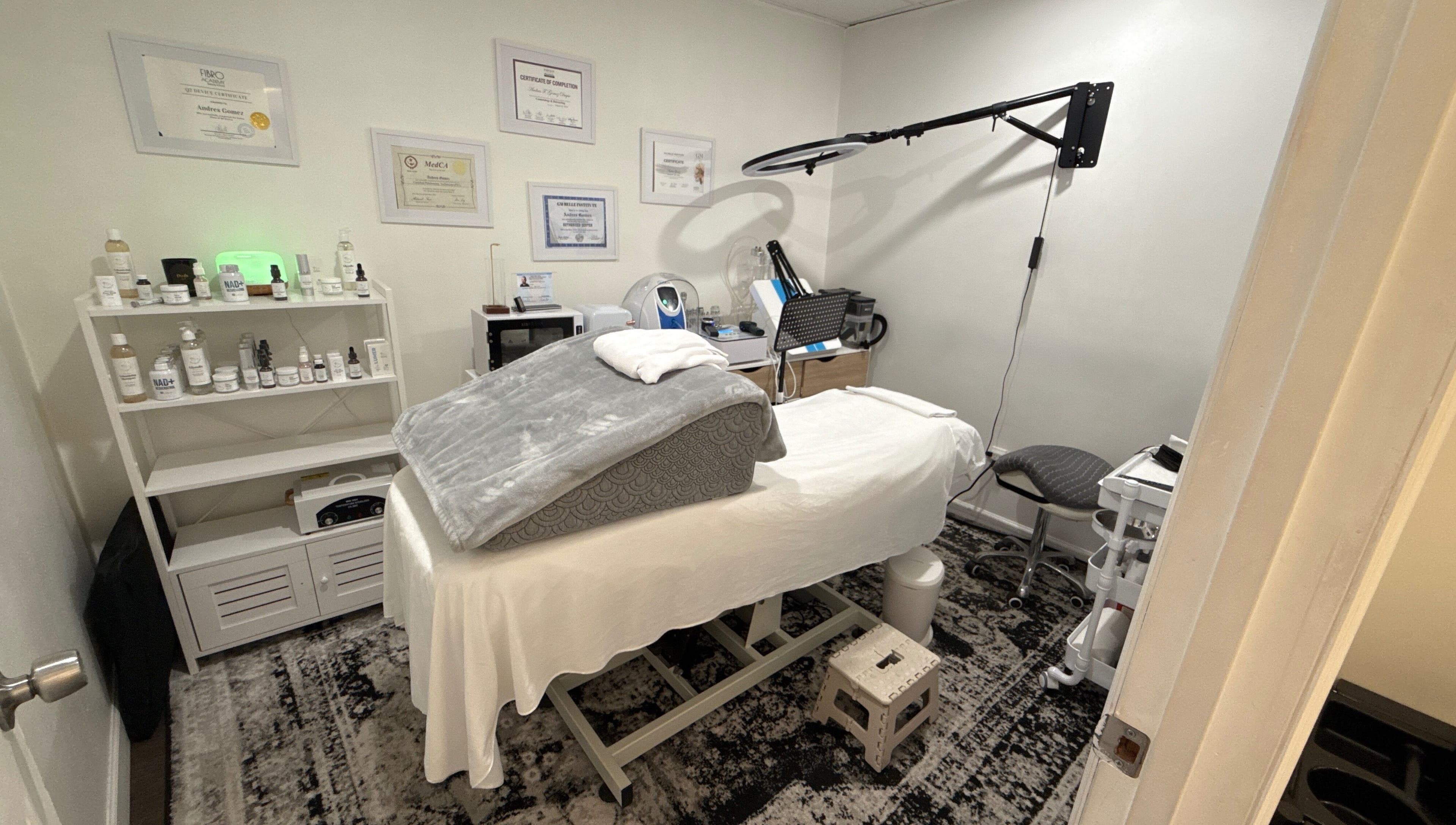 Sala de tratamiento en Your Skincare Plus, Garfield, New Jersey, US, con cama de spa y productos de belleza.