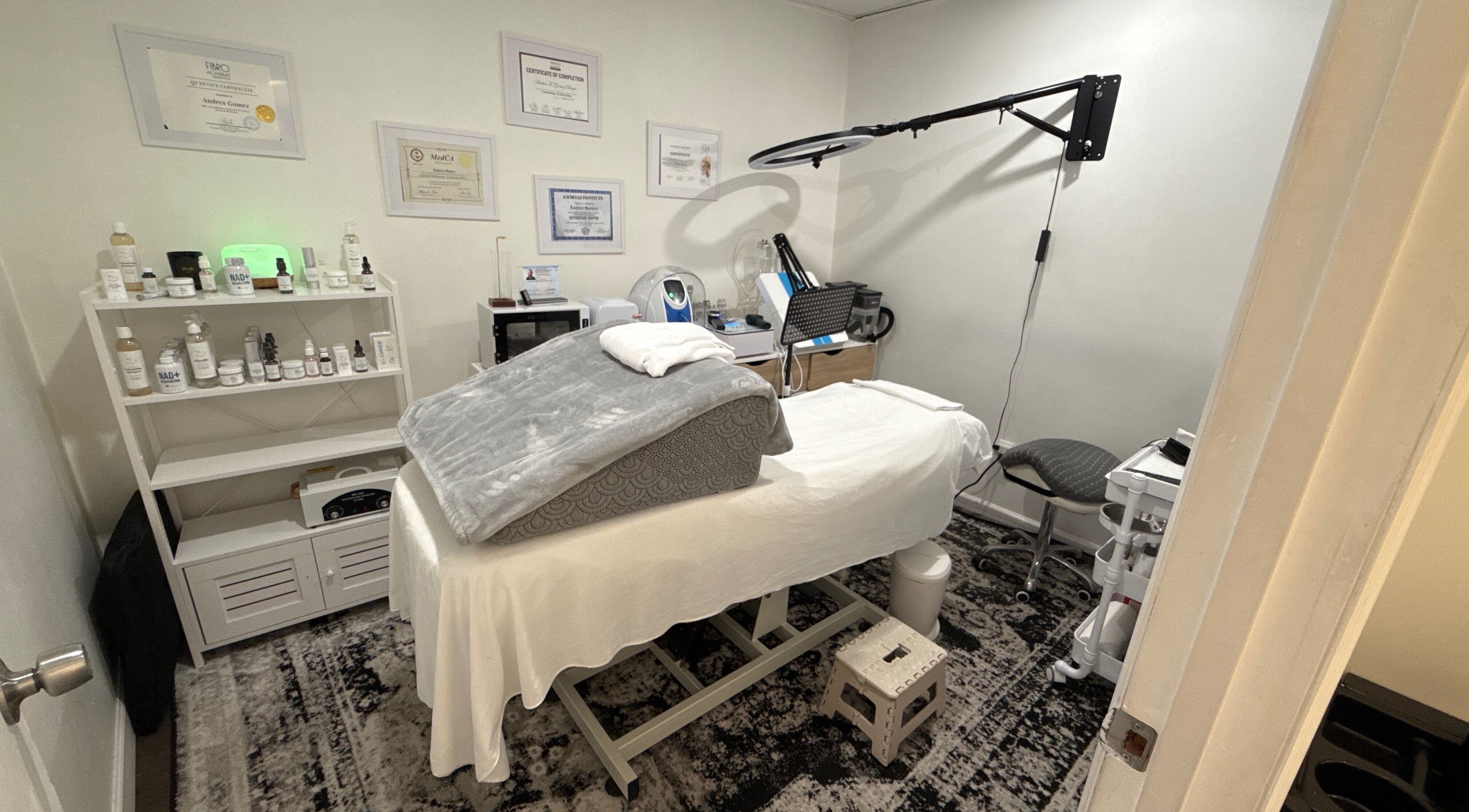 Sala de tratamiento en Your Skincare Plus, Garfield, New Jersey, US, con cama de spa y productos de belleza.