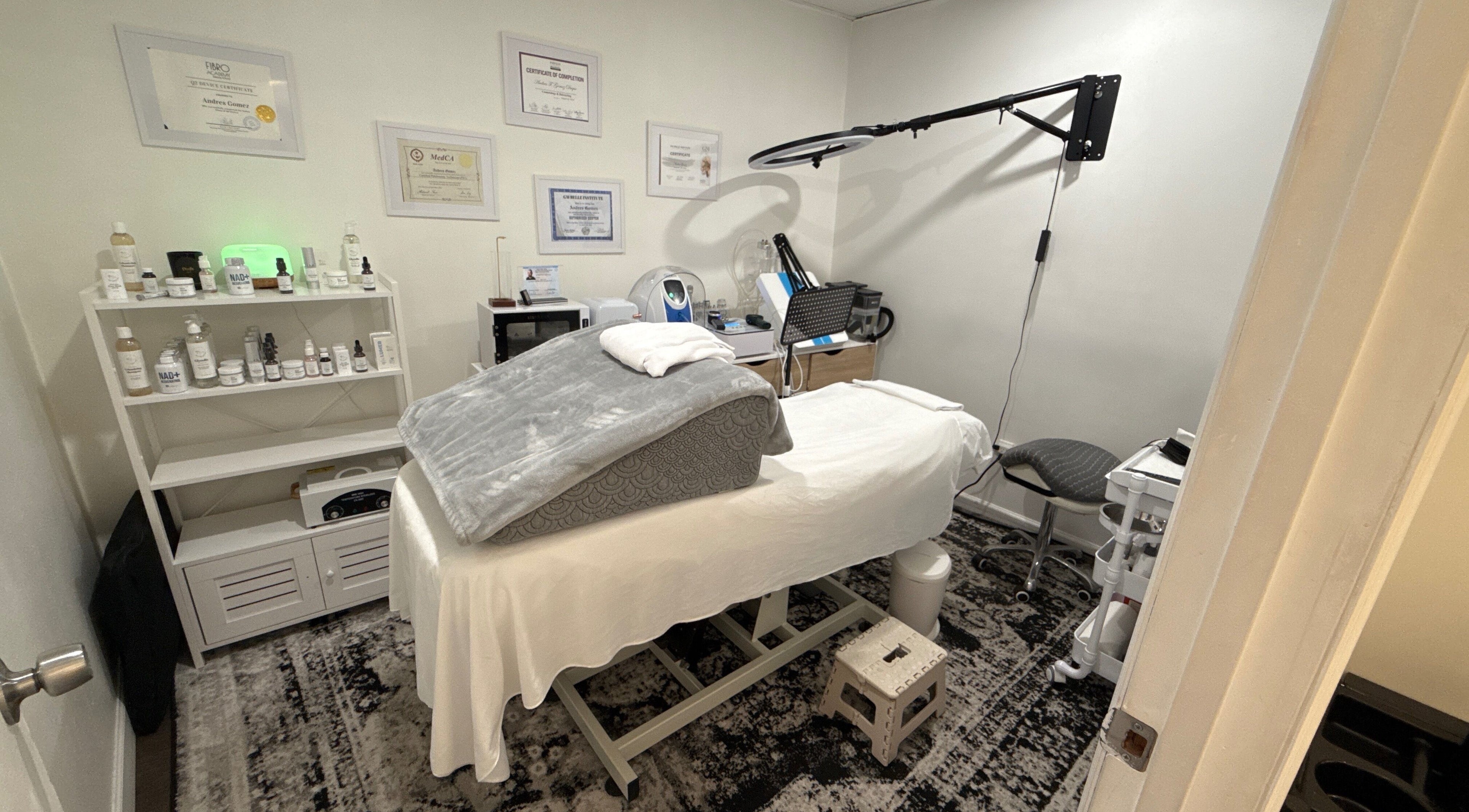 Sala de tratamiento en Your Skincare Plus, Garfield, New Jersey, US, con cama de spa y productos de belleza.