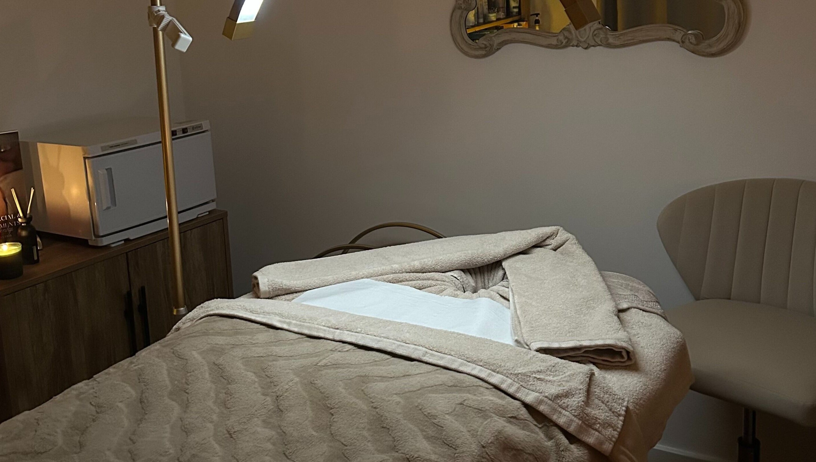 A tranquil treatment room at Spa Ukiyo, Stafford, England, GB, featuring a plush massage bed and ambient lighting.