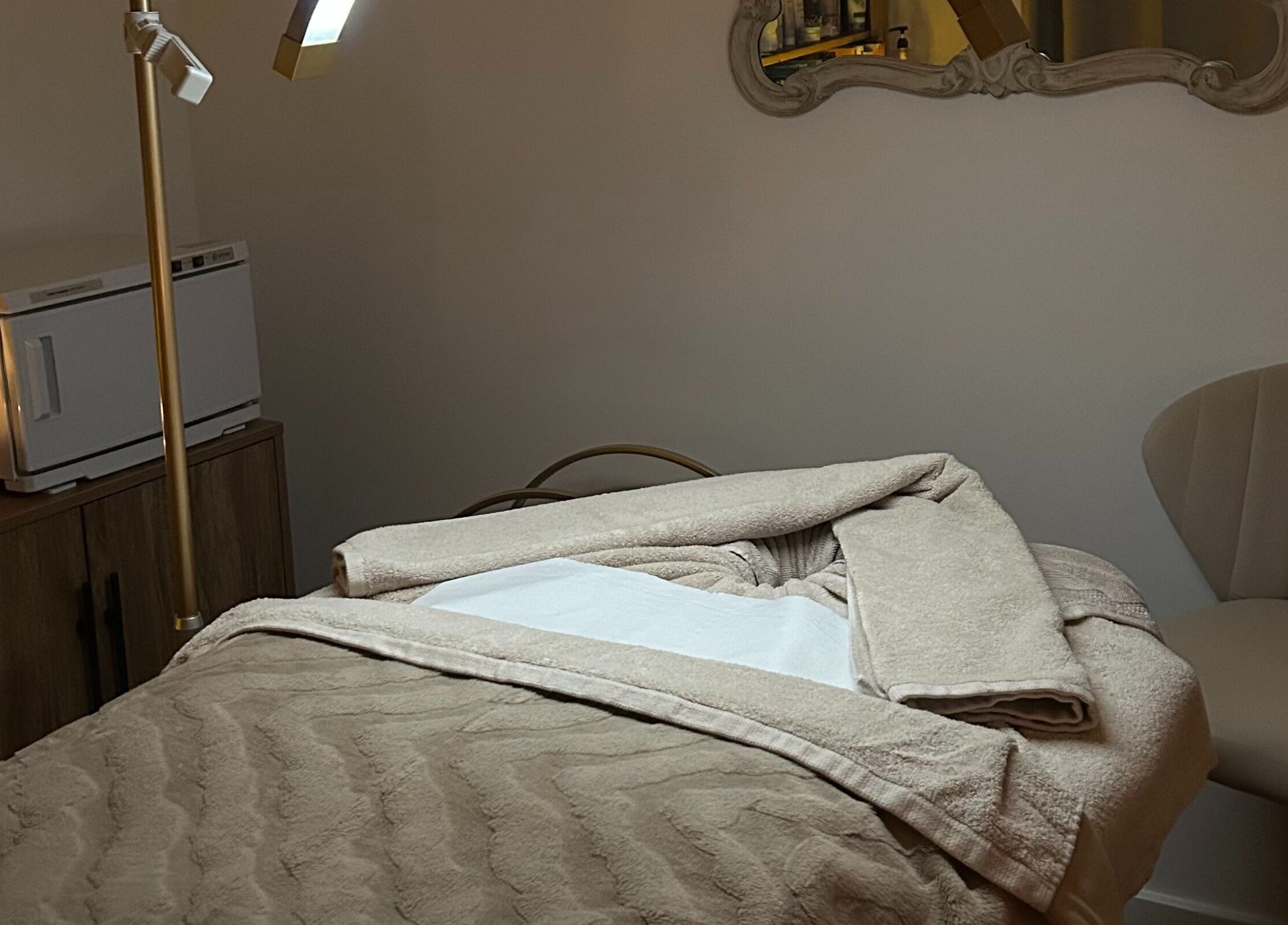 A tranquil treatment room at Spa Ukiyo, Stafford, England, GB, featuring a plush massage bed and ambient lighting.