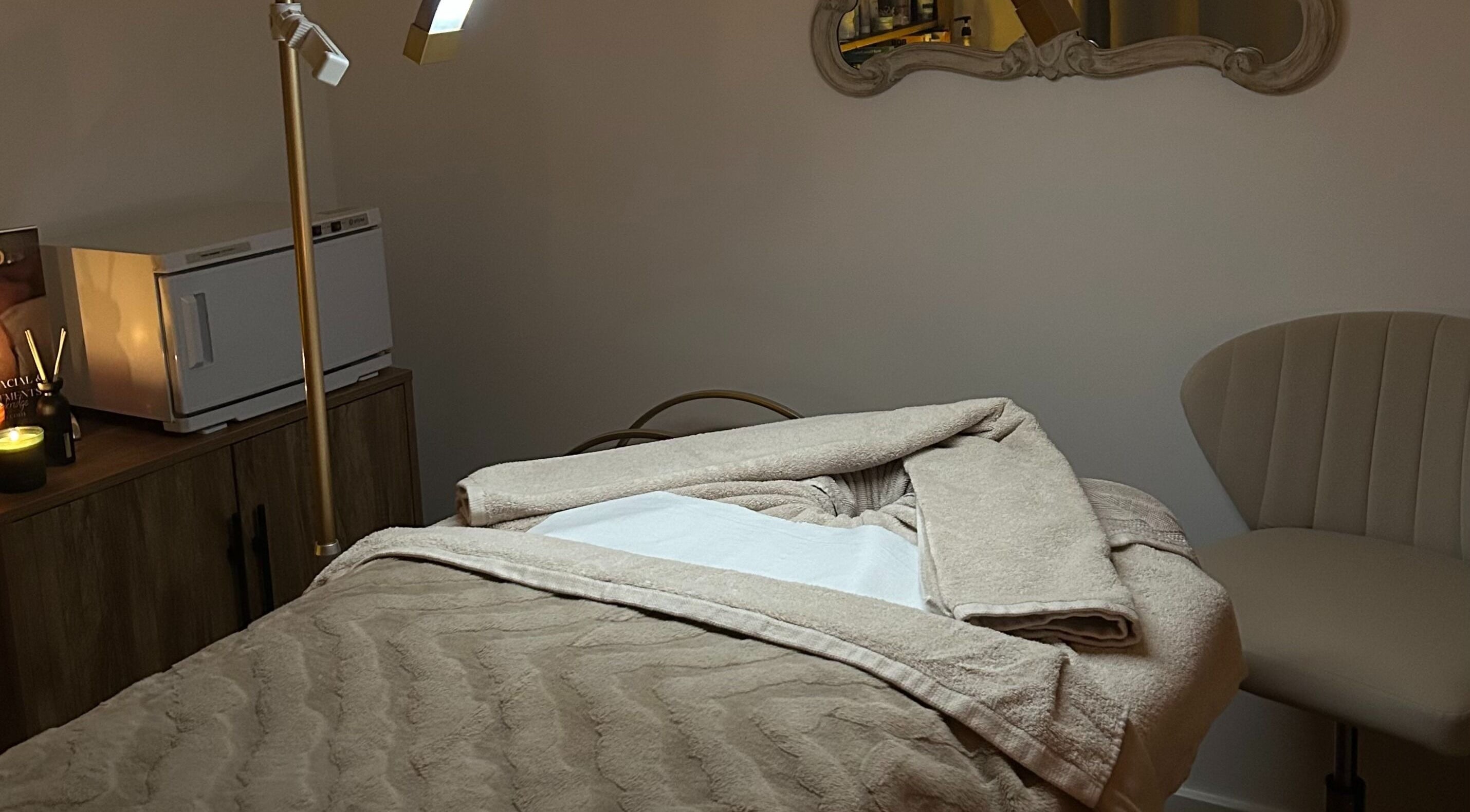 A tranquil treatment room at Spa Ukiyo, Stafford, England, GB, featuring a plush massage bed and ambient lighting.