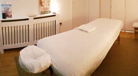 A peaceful massage room at Everwell Massage Therapies - Lynnea, Brynsadler, Wales, GB, featuring a cozy massage bed.