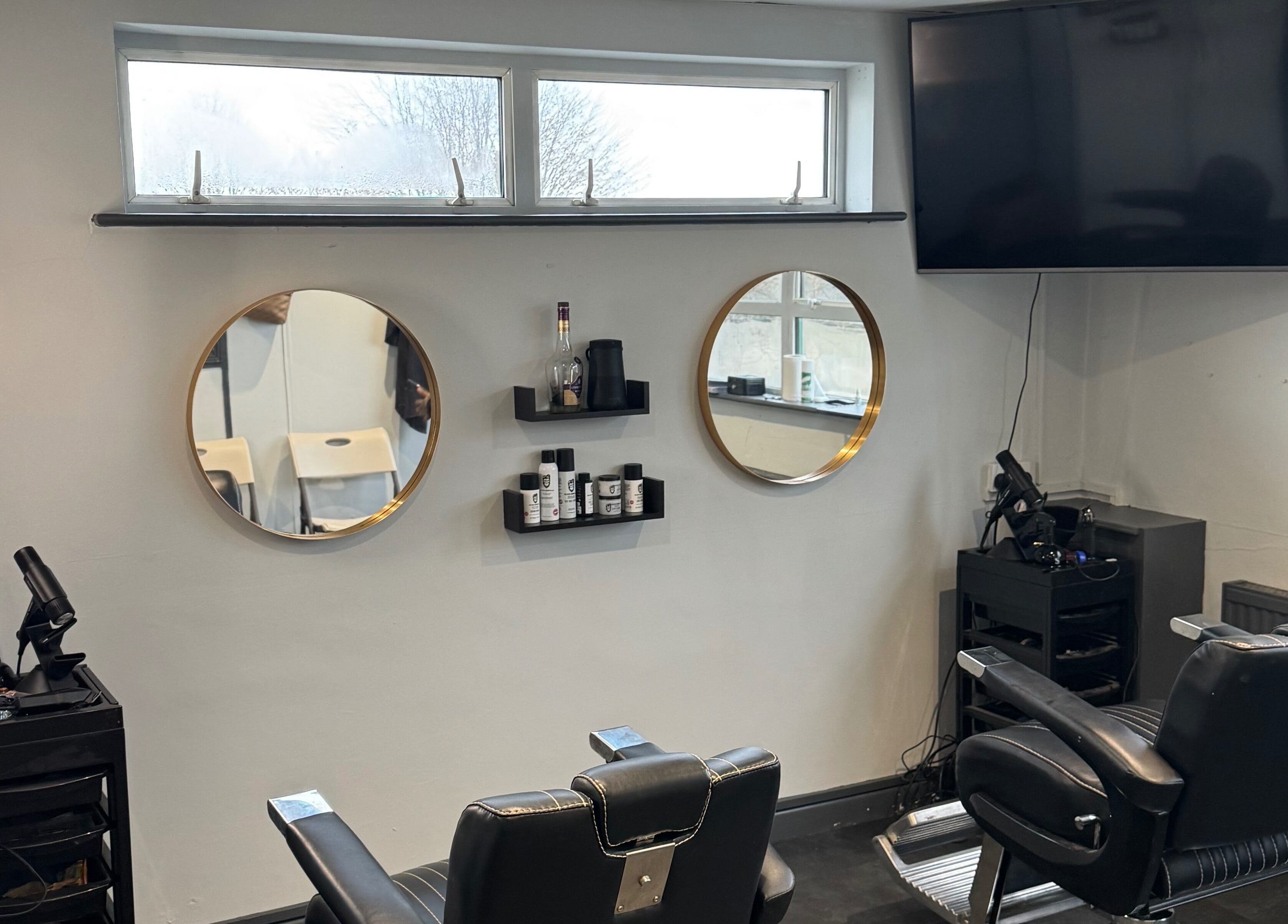 Modern barber chairs at S.B.T Impact Barbers in Old Sarum, England, GB with stylish mirrors and equipment.