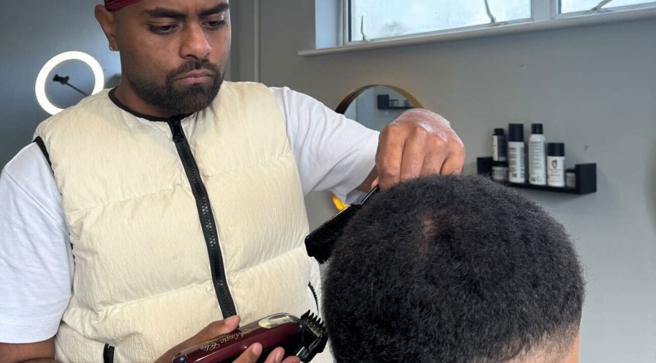 Professional barber cutting hair at S.B.T Impact Barbers, Old Sarum, England, GB.