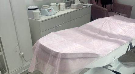 Sala de tratamento no Marisa Craveiro Sugaring em Coimbra, PT com uma marquesa coberta com tecido rosa.