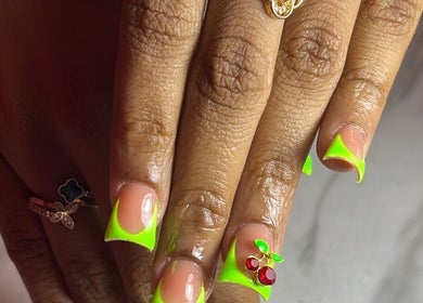 Neon green french tip nails with cherry accents at Klassybarbz, Scarborough, Tobago, TT.