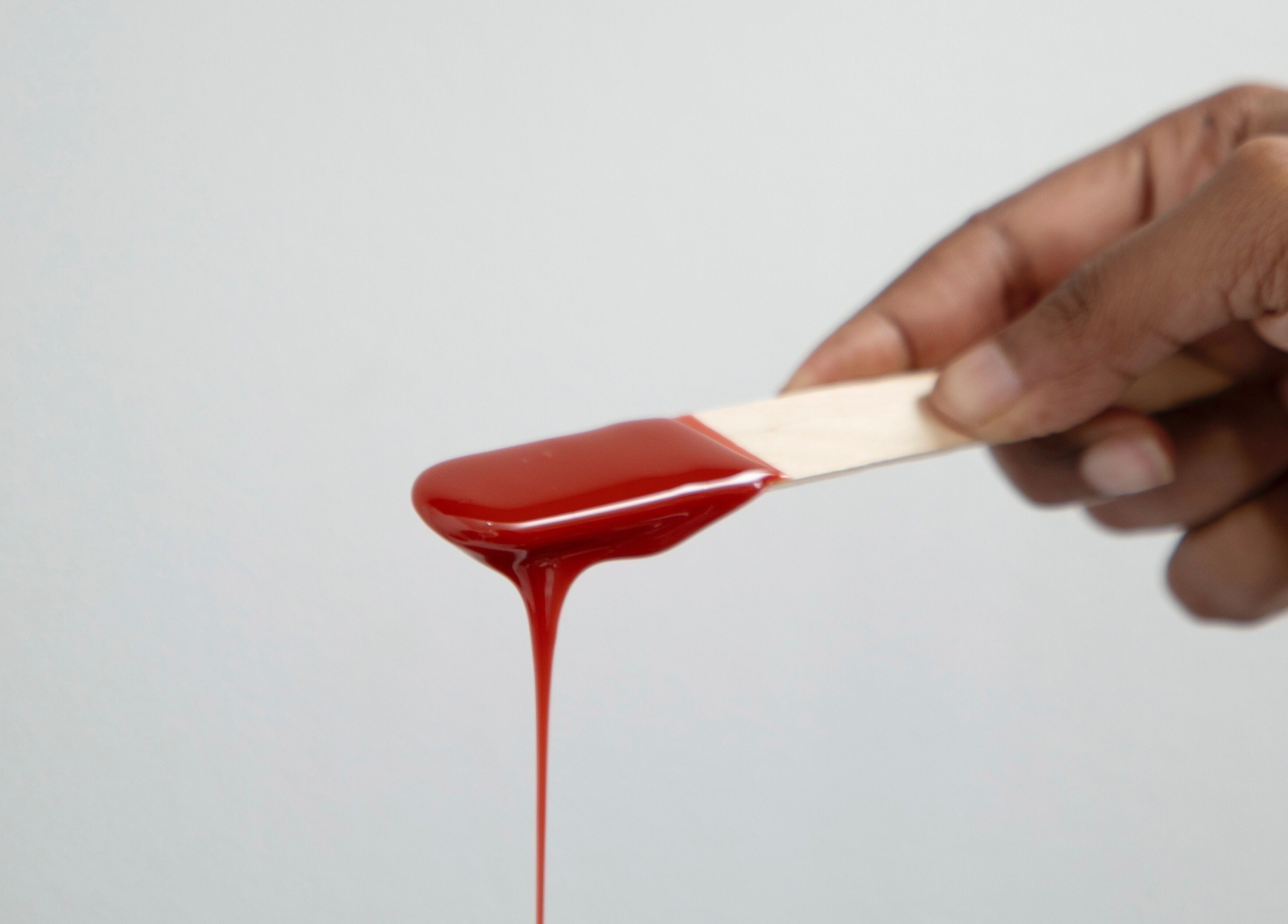 Warm red wax on a stick at Kayswaxingroom, Umhlanga, Kwazulu-natal, ZA. Experience smooth, professional care.