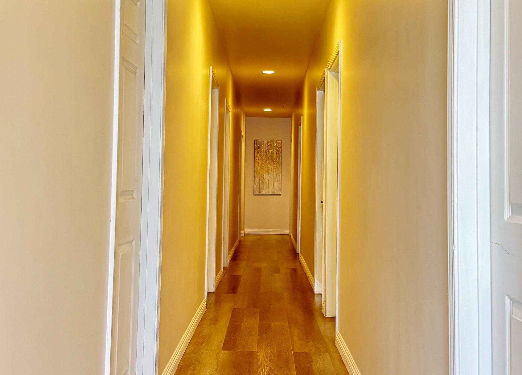 Warmly lit hallway at Bosmar Spa in San Diego, California, US, featuring wooden floors and soft lighting.