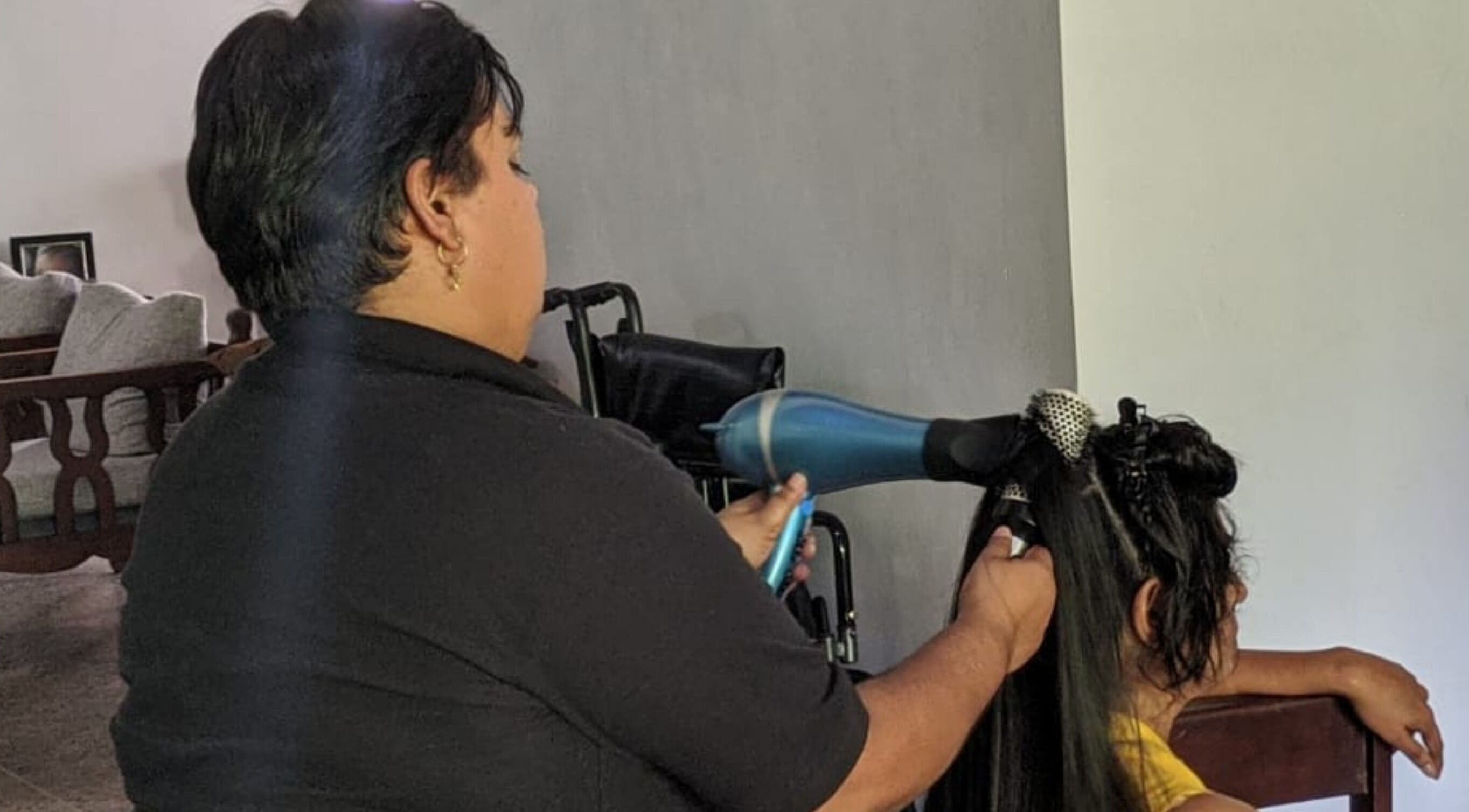 Stylist at KB Styles TT expertly blow-drying client's hair for a sleek finish.