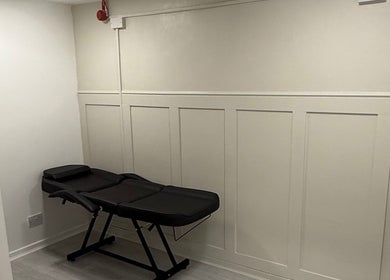 Minimalist piercing room at Anya Celyn Piercings, Amlwch, Wales, GB, with a sleek black chair.
