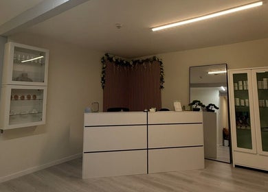 Reception area at Anya Celyn Piercings, Amlwch, Wales, GB, featuring modern decor and display cabinets.