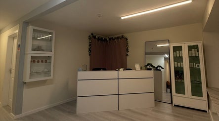Reception area at Anya Celyn Piercings, Amlwch, Wales, GB, featuring modern decor and display cabinets.