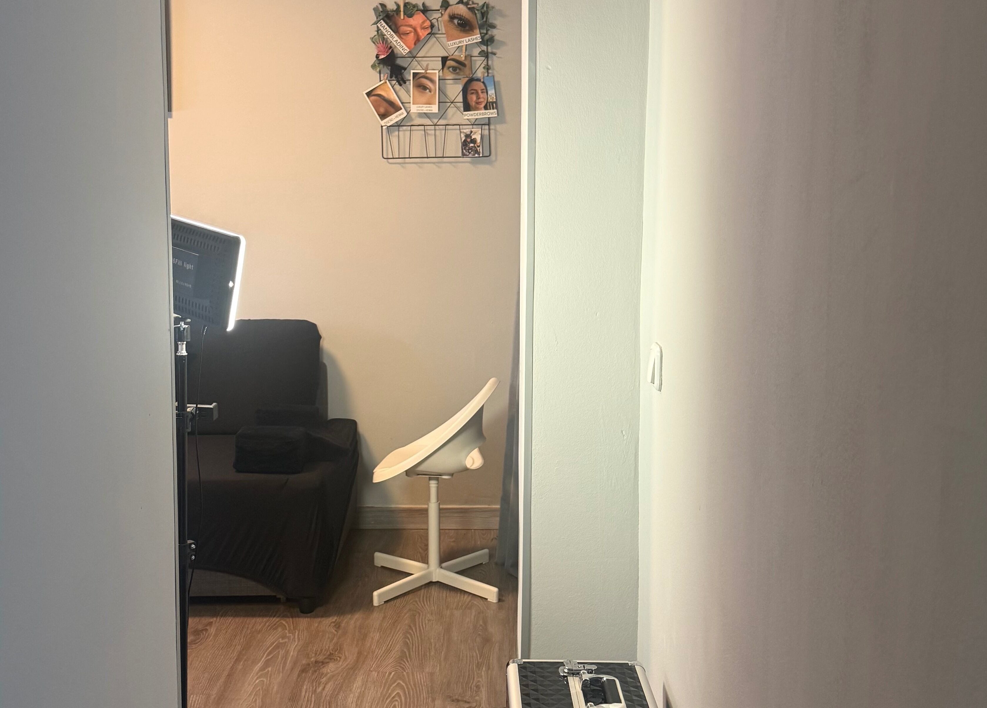 Espacio acogedor en Kyiscejas, Barcelona, Catalunya, ES, con silla blanca y decoración de fotos.