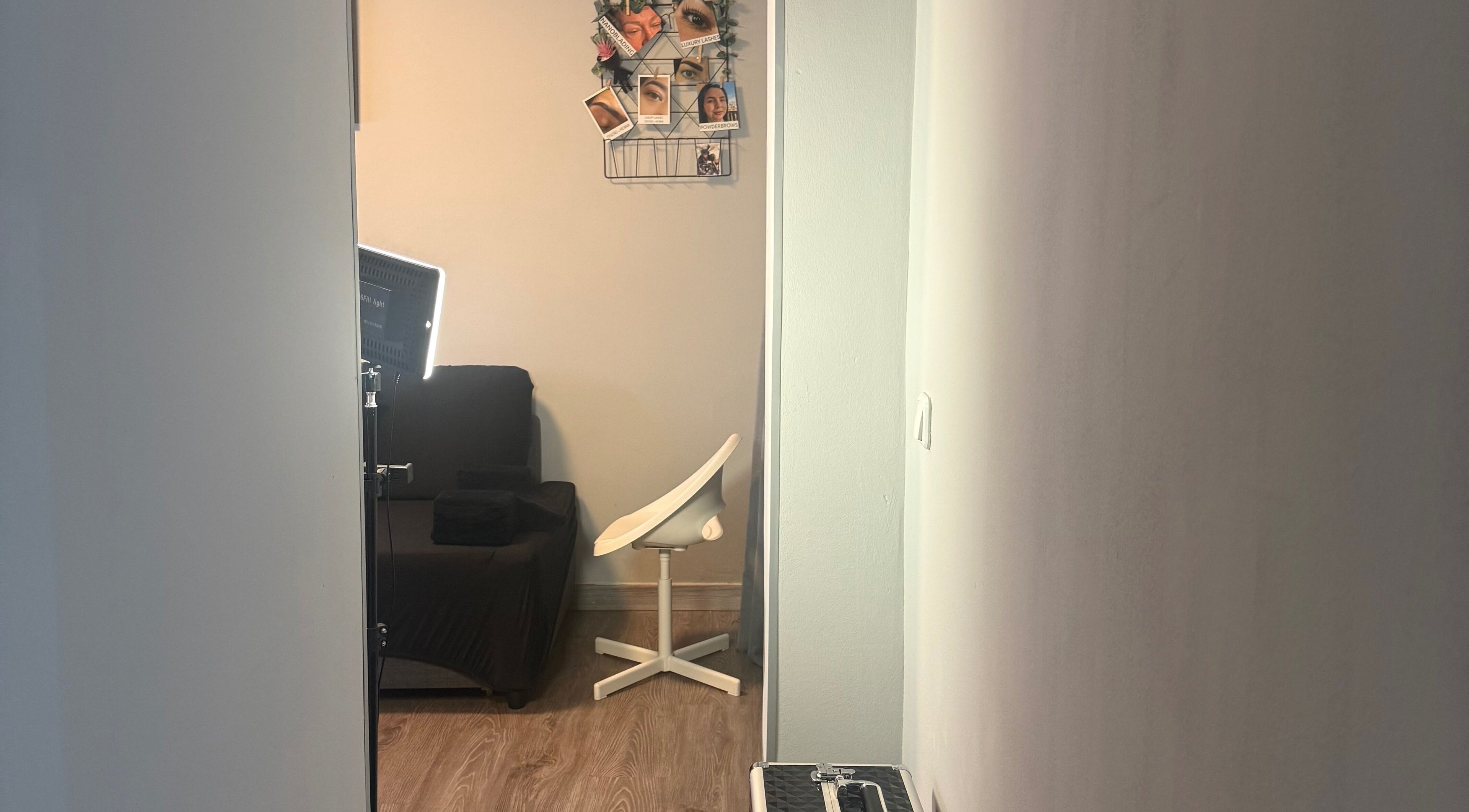 Espacio acogedor en Kyiscejas, Barcelona, Catalunya, ES, con silla blanca y decoración de fotos.