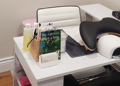 Nail station setup at Devo Esthetics, Ste-anne-de-prescott, Ontario, CA with manicure tools and eco-friendly sign.