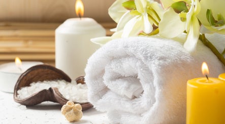 Bougie allumée et serviette blanche à CréoliaSens, Baie-mahault, Basse-terre, GP, illustrant une ambiance de spa.