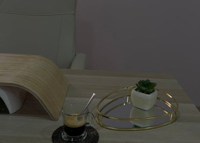 Mesa de manicure elegante no Cure Aesthetic Nails, Carnaxide, Lisboa, PT, com café e decoração minimalista.