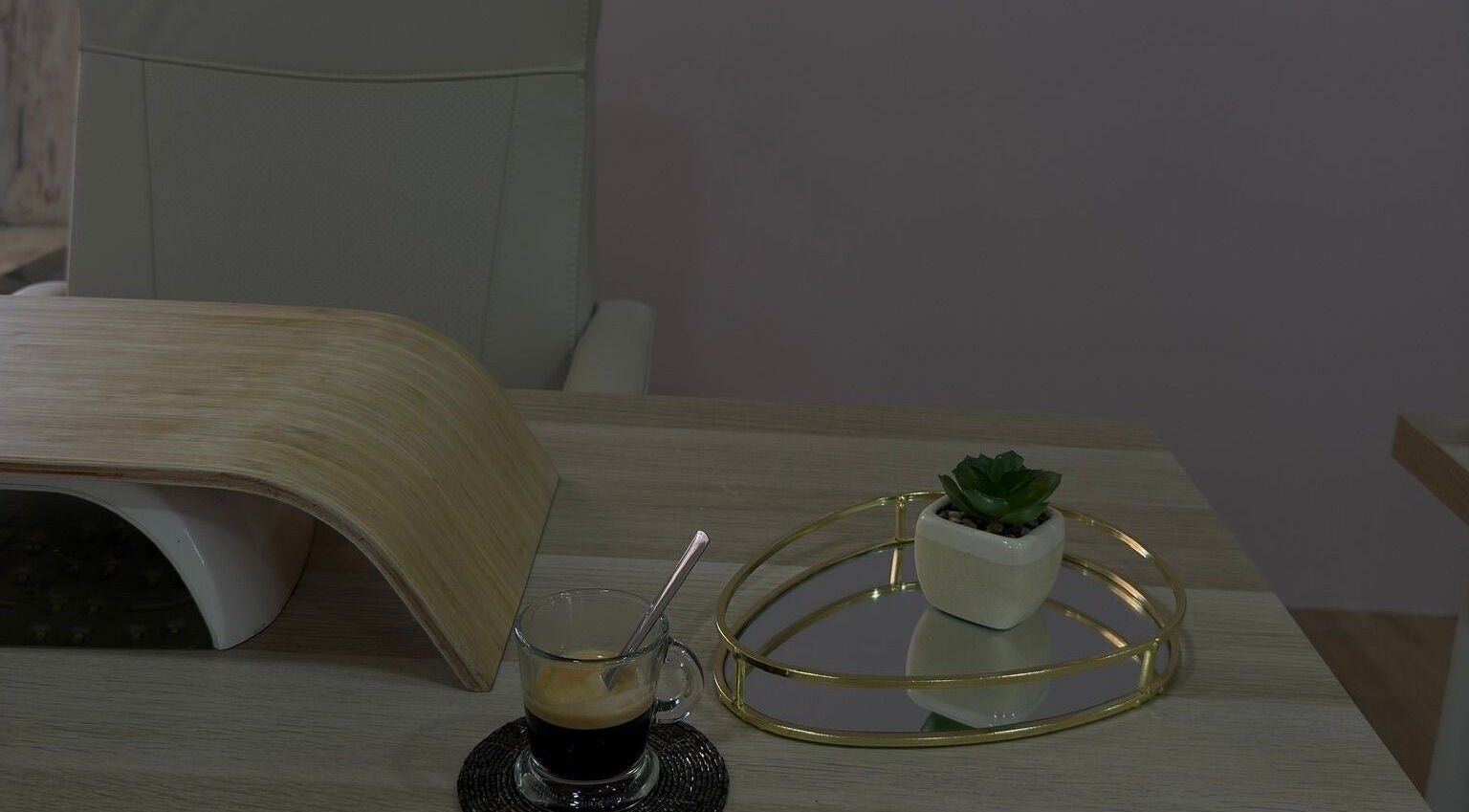 Mesa de manicure elegante no Cure Aesthetic Nails, Carnaxide, Lisboa, PT, com café e decoração minimalista.