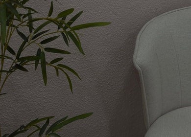 Interior elegante do Cure Aesthetic Nails em Carnaxide, Lisboa, PT, com cadeira cinza e planta decorativa.
