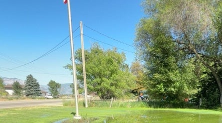 Outdoor area near LashnBrow.byTaylor in Ogden, Utah, US, featuring lush trees and a clear blue sky.