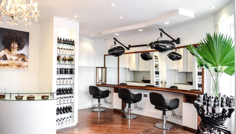 Chic salon interior at Glamzy, Western Province, LK, featuring stylish chairs and hair care products.