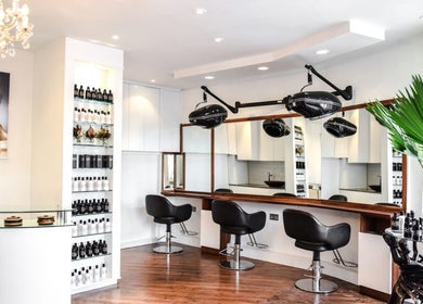 Chic salon interior at Glamzy, Western Province, LK, featuring stylish chairs and hair care products.