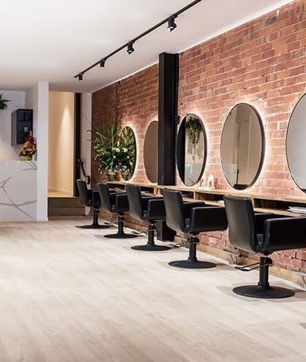 Modern salon interior at Glamzy in Western Province, LK with elegant styling stations and chic chairs.