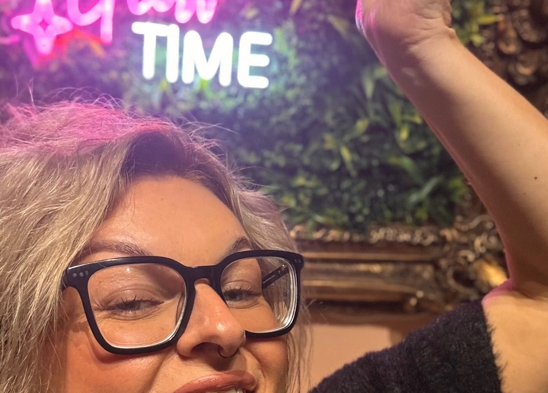 Bright neon sign at Tan with Topps in Torquay, England, GB, creating a vibrant welcoming atmosphere.