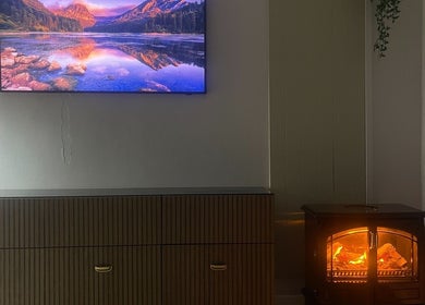Fireplace and TV at Cultured Curls, London, England, GB, creating a warm ambiance in the venue.