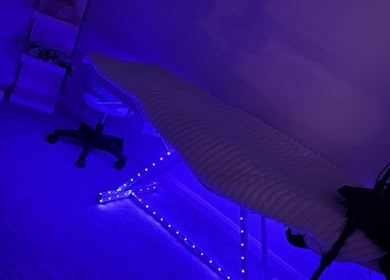 Tranquil treatment room at E.loubeauty, Poole, England, GB, featuring calming blue lights and a cozy chair.