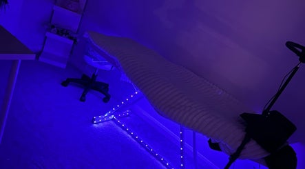 Tranquil treatment room at E.loubeauty, Poole, England, GB, featuring calming blue lights and a cozy chair.