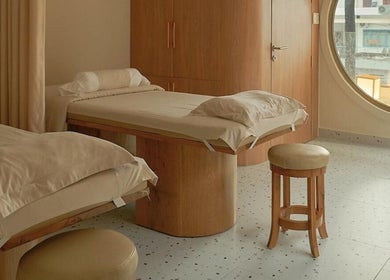 Phòng spa tại Imakoko, Hồ Chí Minh với giường đôi, thiết kế gỗ sang trọng, cửa sổ tròn thoáng đãng.