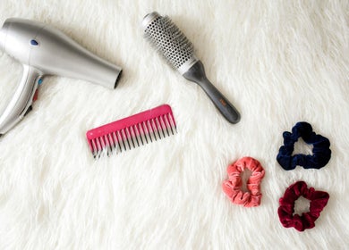 Hair styling tools at Edmond Bunce Hairdressing, Hamilton, Scotland, GB, featuring dryer, brush, comb, and scrunchies.