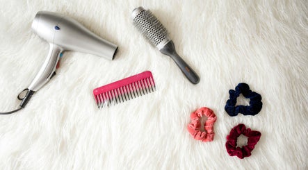 Hair styling tools at Edmond Bunce Hairdressing, Hamilton, Scotland, GB, featuring dryer, brush, comb, and scrunchies.