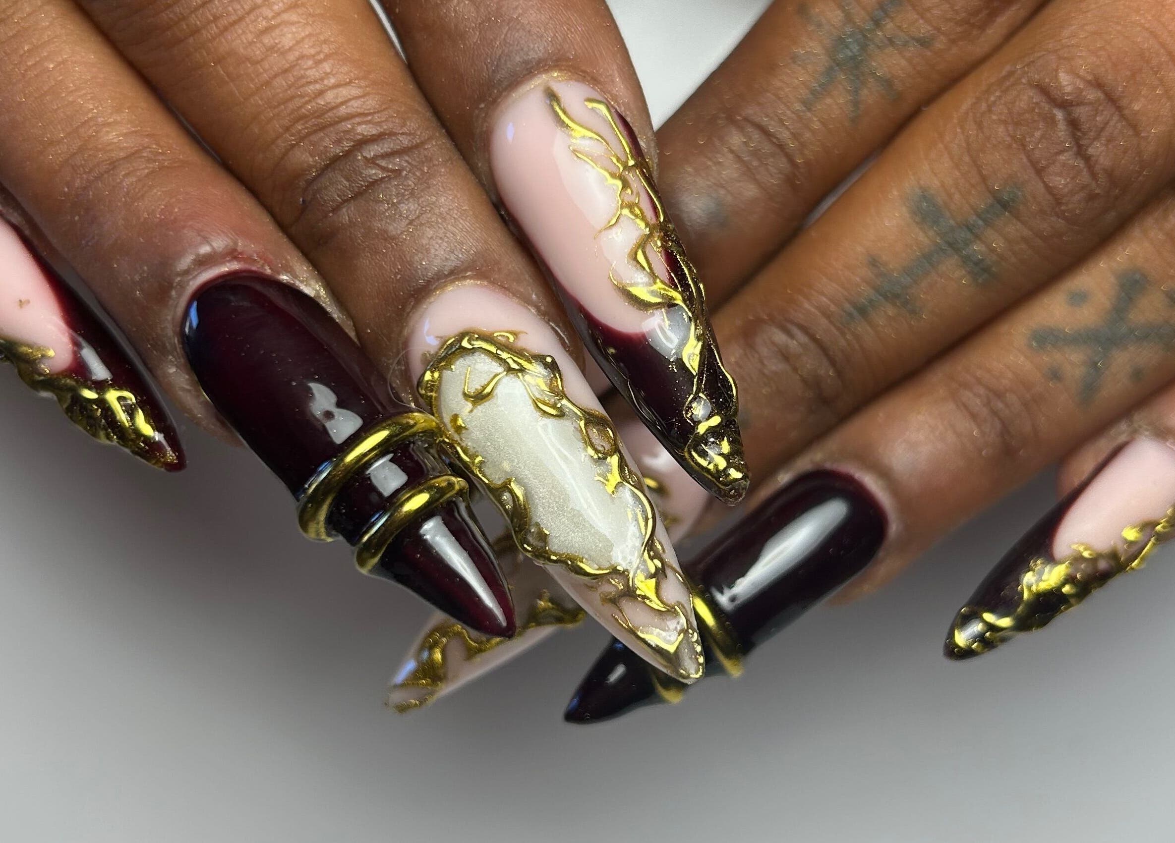 Art de l'ongle doré et bordeaux à Loubies en folies, Montpellier, Occitanie, FR.