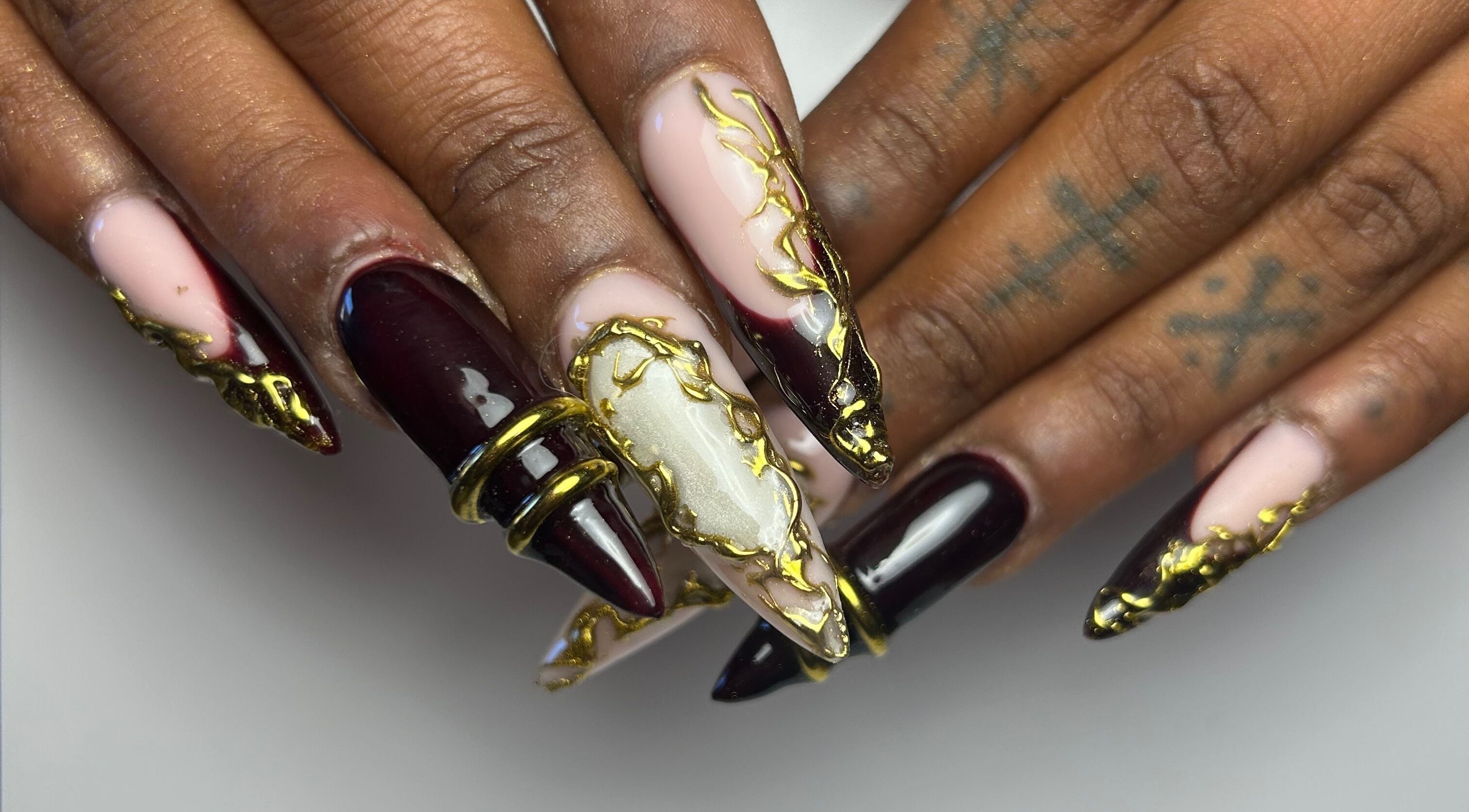 Art de l'ongle doré et bordeaux à Loubies en folies, Montpellier, Occitanie, FR.