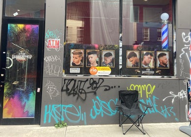 Vibrant entrance of Eraylin ‘FadeByE’ in New York, New York, US showcasing barber styles and street art.