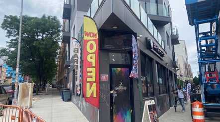 Street view of Fade By Eraylin in New York, New York, US with colorful banners and sidewalk.