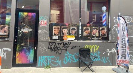 Street view of Fade By Eraylin showcasing haircut posters and vibrant graffiti, New York, New York, US.