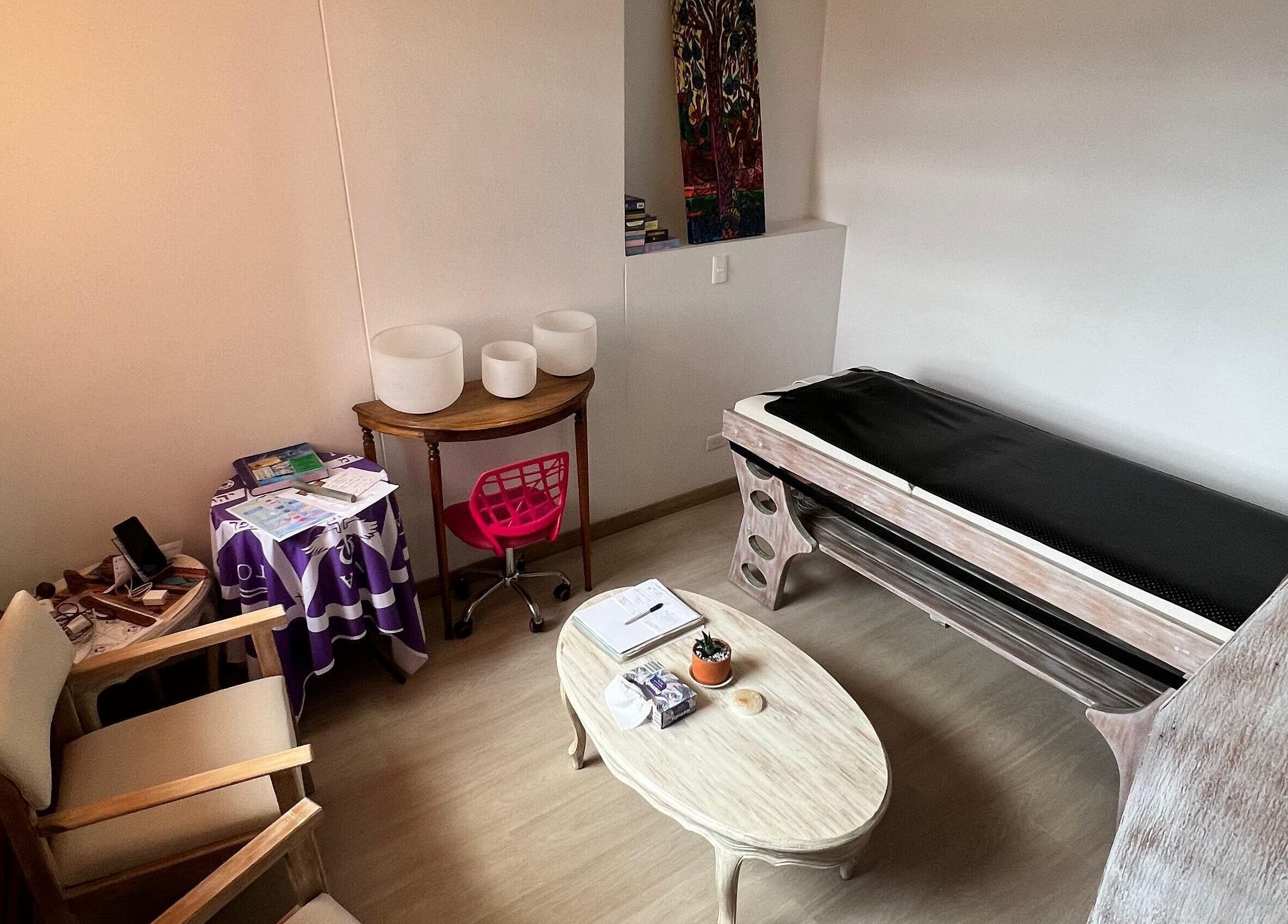 Acogedora sala de terapia en Naty Garzon Angeles, Envigado, Antioquia, CO con sillas y camilla.