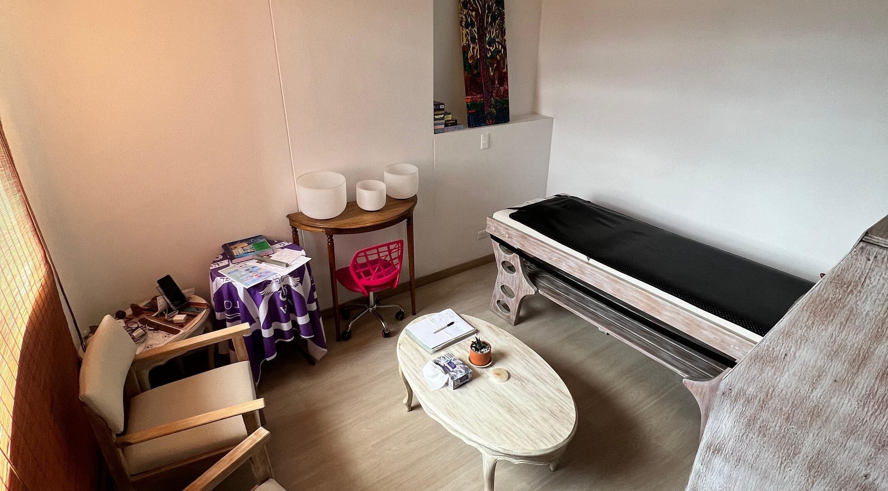 Acogedora sala de terapia en Naty Garzon Angeles, Envigado, Antioquia, CO con sillas y camilla.