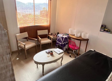Sala de espera tranquila en Naty Garzon Angeles, Envigado, Antioquia, CO, con sillas cómodas y mesa elegante.