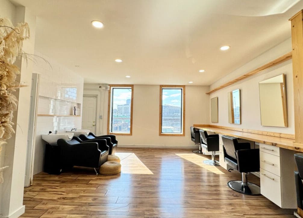 Bright, stylish salon interior at KC Braiding Bar in Kansas City, Missouri with modern chairs and wooden flooring.
