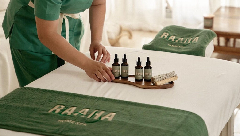 Raaha Wellness - Home Service massage oils in Dubai, AE, displayed on a spa bed.