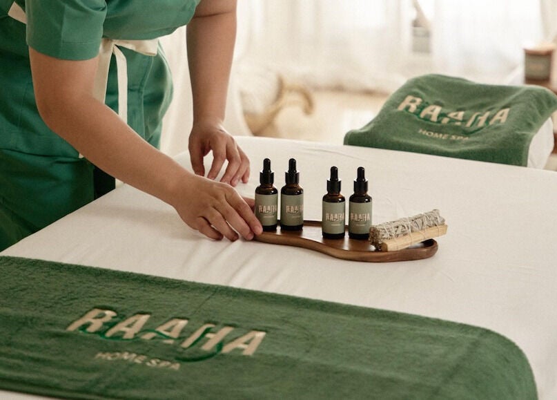 Raaha Wellness - Home Service massage oils in Dubai, AE, displayed on a spa bed.