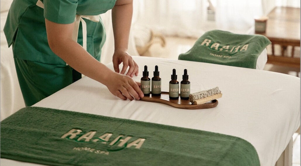 Raaha Wellness - Home Service massage oils in Dubai, AE, displayed on a spa bed.